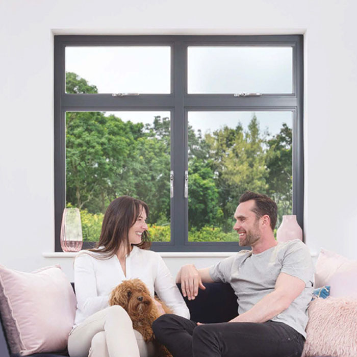 Origin OW-70 aluminium window with a couple sitting in front on a sofa